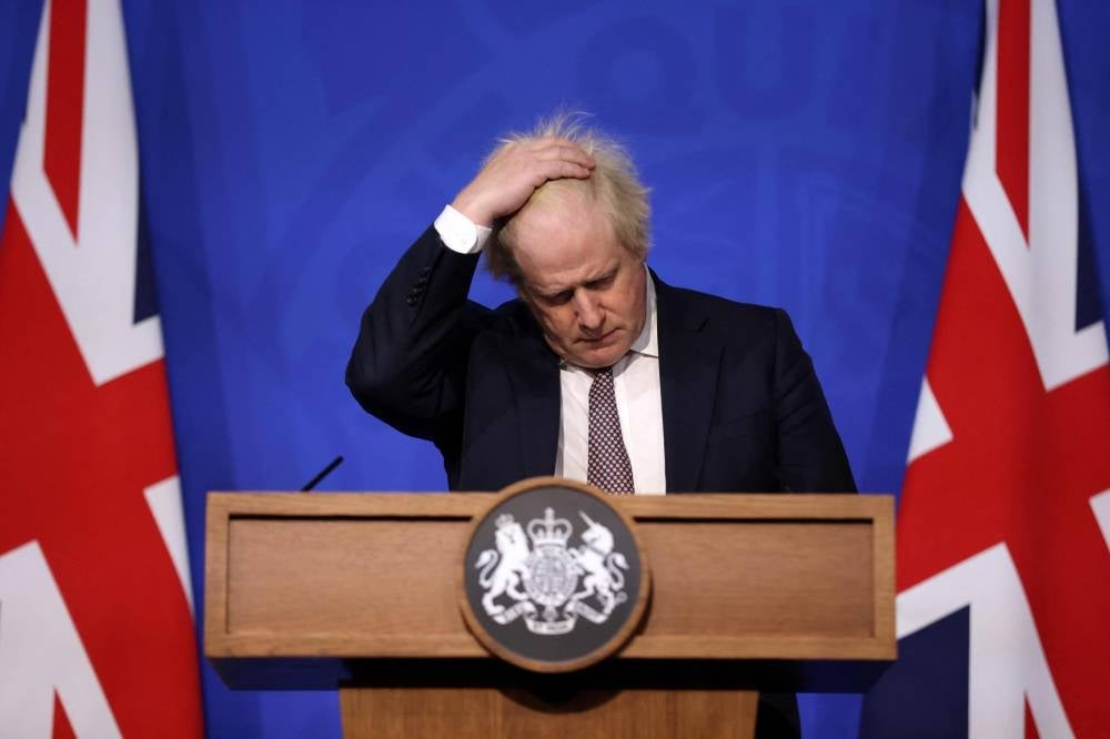 In this file photo taken on November 27, 2021 Britain's then prime minister Boris Johnson gestures as he attends a media briefing on the latest Covid-19 update in the Downing Street briefing room in central London. (Photo by Hollie Adams / AFP)