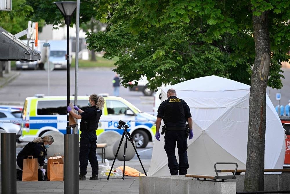 Police forensic officers work at the scene of a shooting incident at Farsta shopping center in the south of Stockholm on June 10, 2023. (Photo by Anders WIKLUND / various sources / AFP) / Sweden OUT
