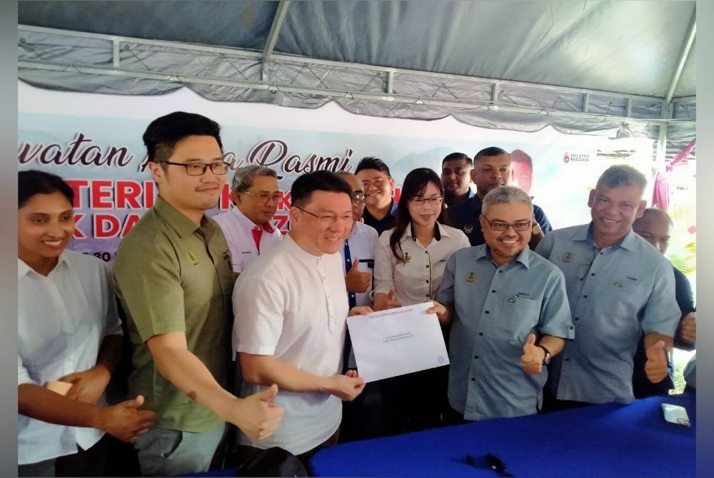Nga Kor Ming (three from left) presenting the approval letter to Ipoh mayor Datuk Rumaizi Bahrin in a press conference after his work visit at Ipoh city, here, on Sunday. 