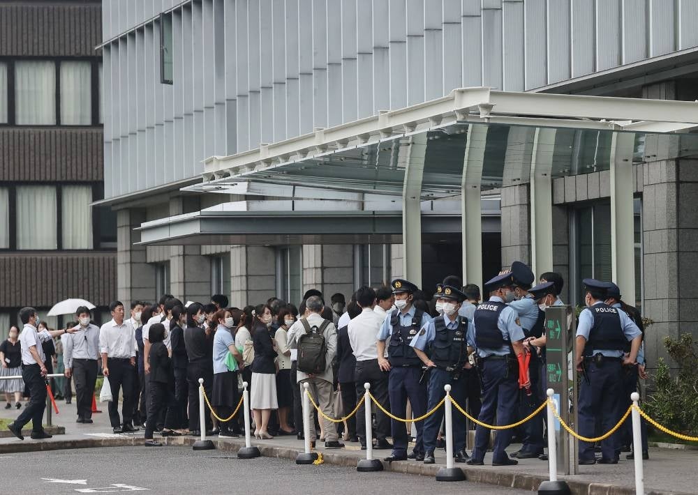 Staff members stand outside the Nara District Court after temporarily evacuating from the building after a suspicious object was delivered during the pre-trial hearing for Tetsuya Yamagami, the man accused of killing Japan's former prime minister Shinzo Abe, in Nara on June 12, 2023. Photo by Jiji Press/AFP.