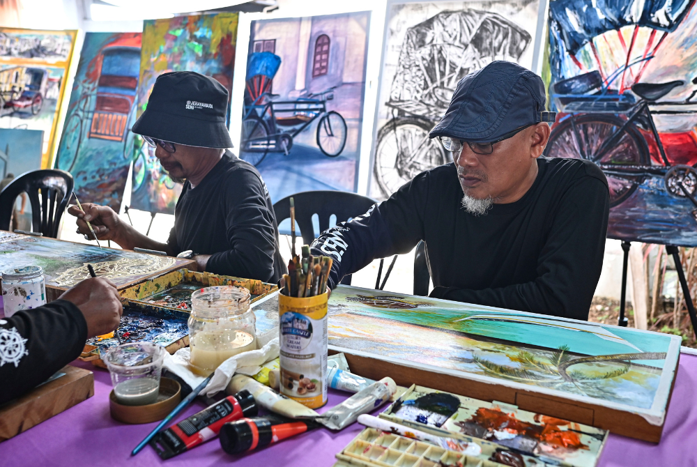 Artists diligently working on their art pieces that fit the theme 'Lindungan dan Dagangan' during Kuala Terengganu Double Season Roadshow programme. Photo: BERNAMA
