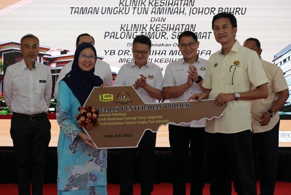 JOHOR BAHRU, June 18 - Health Minister Dr Zaliha Mustafa receiving a key replica from Public Works (Building sector) deputy director general Ir Badioezaman Abd Khalik as a gimmick of handing over of Pathology Laboratory Project of Sultanah Aminah Hospital (HSA) Johor Bahru, Taman Ungku Tun Aminah Health Clinic Johor Bahru and Palong Timur Health Clinic, Segamat at HSA today. - BERNAMA photo (2023) COPYRIGHT RESERVED