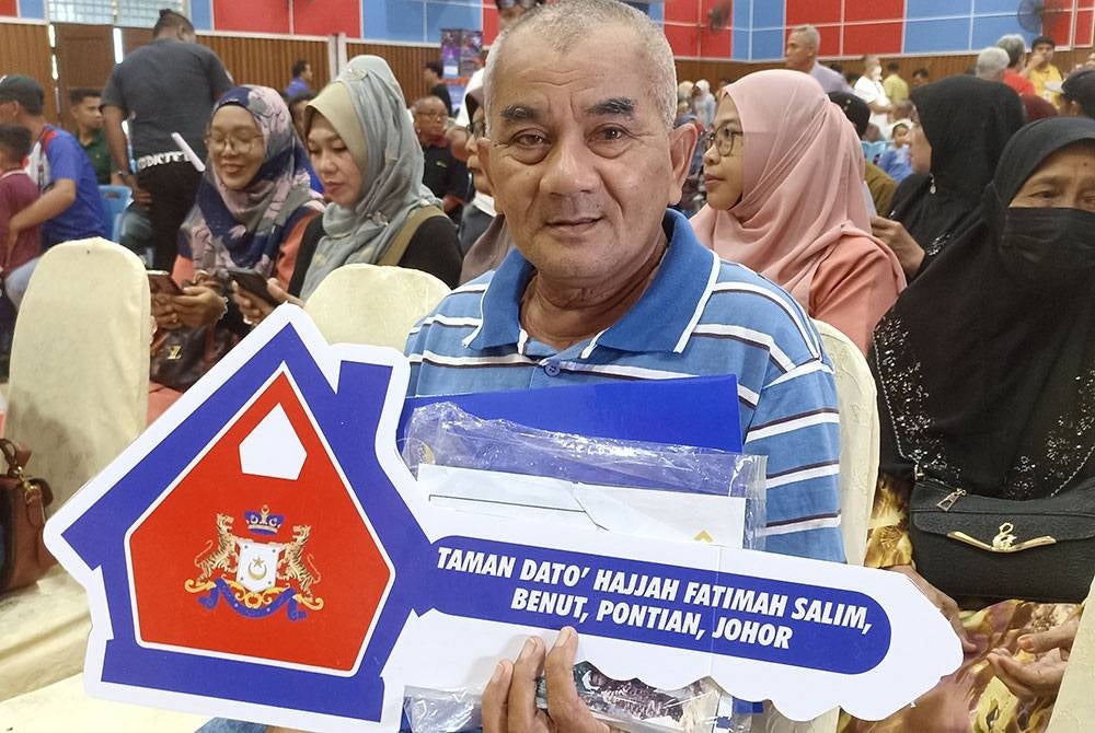 Daim is among the recipients of the keys to a new house in Taman Datuk Hajjah Fatimah Salim, Benut.
