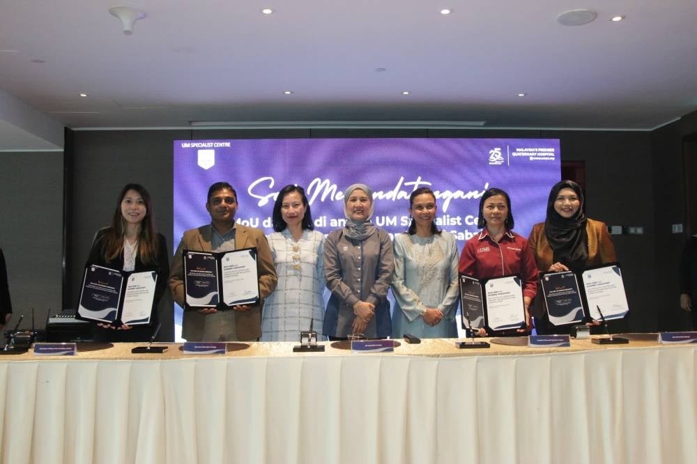 Norzaiton (sixth in line ) with a line of representatives who signed the MoUs from public and private HEIs at a ceremony held in Kota Kinabalu - FILE PIX