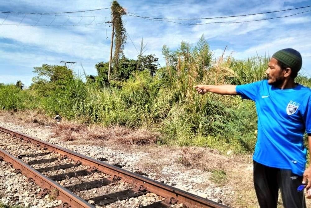 Osman showing the location of the incident at the railway track in Kampung Palekbang.