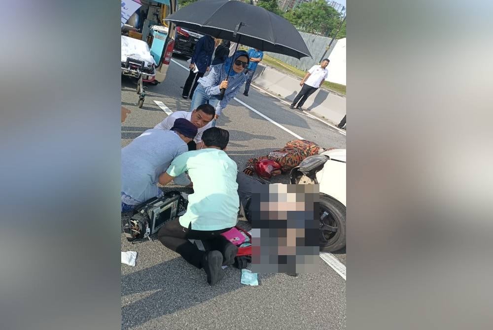 Johor Menteri Besar Datuk Onn Hafiz Ghazi helping a crash victim at Jalan Danga Bay, Johor Bahru on Monday.