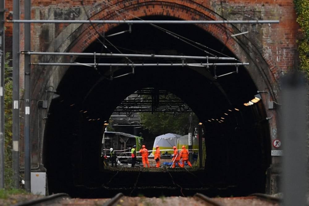 Emergency workers working at the scene of a derailed tram in Croydon, south of London, on Nov 10, 2016. At least seven people were killed and around 50 injured on Nov 9 when a London tram came off the tracks and tipped over. - (Photo by BEN STANSALL / AFP)