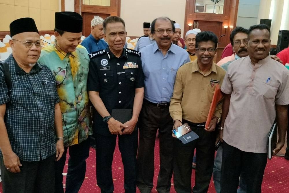 Fisol taking a picture with mosque imams and NGO members.