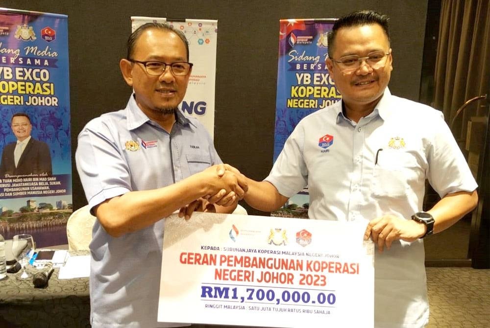 Mohd Hairi (right) with Johor Cooperative Commission of Malaysia (SKM) director after the launching ceremony of Johor Cooperative Construction Grant on Monday.