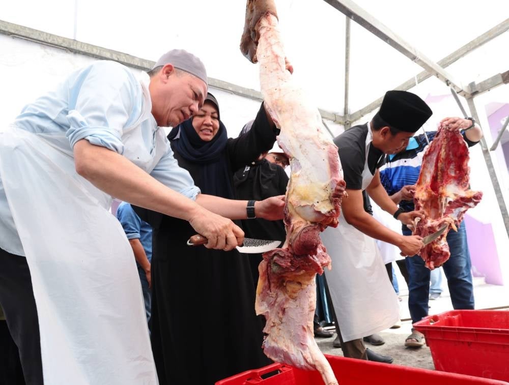 Deputy Prime Minister Datuk Seri Fadillah Yusof and his wife Datin Seri Ruziah Mohd Tahir during the Aidiladha 'korban' (sacrificial slaughter of cows) programme at Surau Darul Fadzillah, Gita Laut, today. - Photo by Bernama