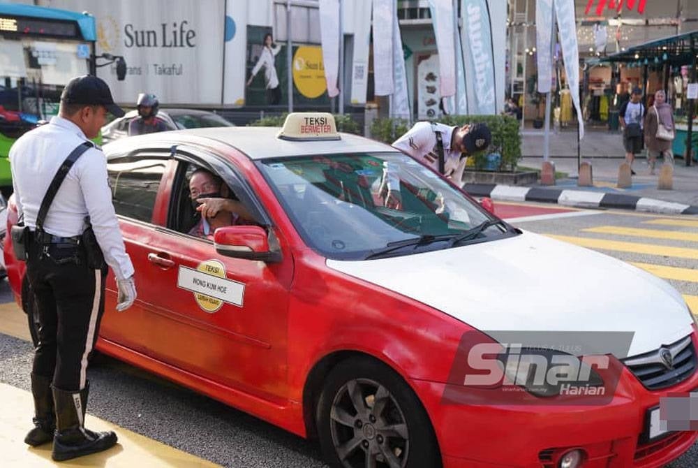 A policeman stopping a traffic offender during Kuala Lumpur Police Obey Traffic Rules Operation on Monday. - Photo: SINAR HARIAN/Rosli Talib.