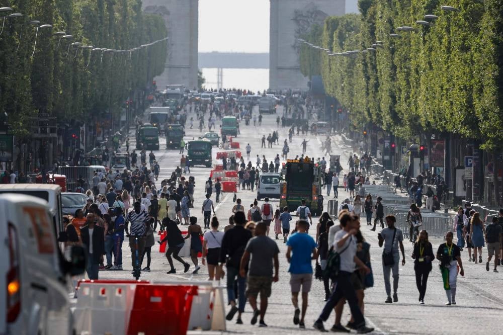 Pedestrians walk on Champs-Elysees avenue in Paris, on July 2, 2023, a day after protesters took to the street and clashed with police on an iconic street popular with tourists during a protest against the police killig of a 17-year-old teenage boy - AFP