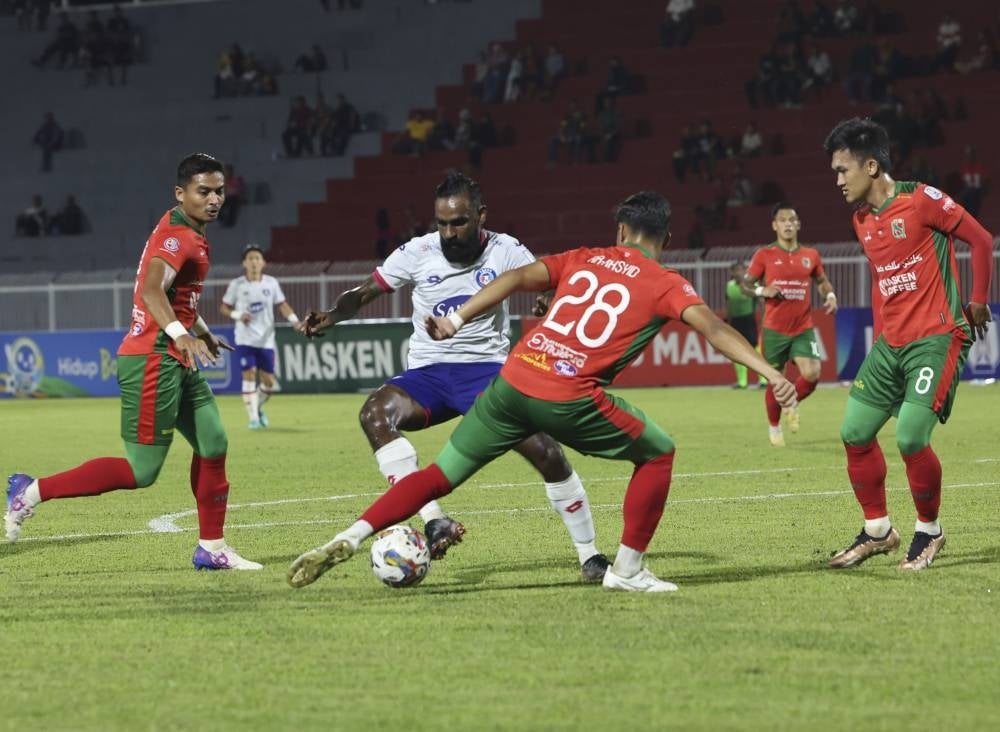 Sabah FC player Gary Steven Robbat (second, left) is tackled by Kelantan United FC players in the Super League match at the Sultan Muhammad IV Stadium - BERNAMA