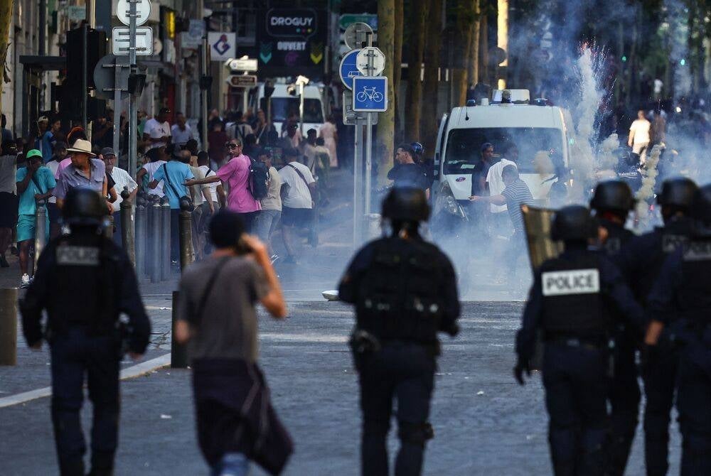 Protesters flee as police tries to disperse them with tear gas during a demonstration against police in Marseille, southern France on July 1, 2023, after a fourth consecutive night of rioting in France over the killing of a teenager by police. (Photo by CLEMENT MAHOUDEAU / AFP)