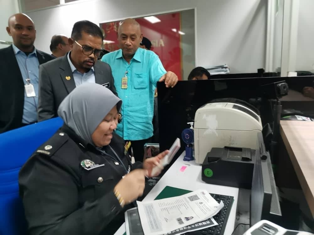 Cuepacs president Datuk Adnan Mat (second from the left) monitoring Immigration Department officers in KLIA1 during his visit on Tuesday.