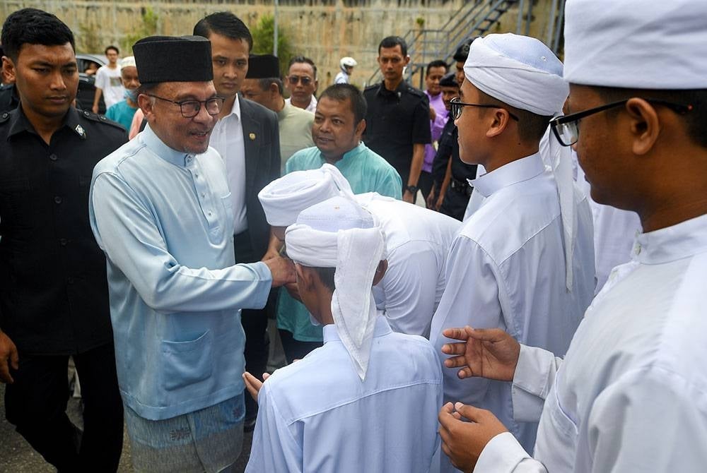 Prime Minister Datuk Seri Anwar Ibrahim (second from left) shaking hands with tahfiz students at the Panchor Jaya Mosque to perform Friday prayers. - Photo by Bernama