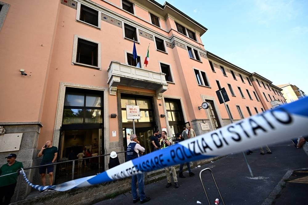 People stand outside a retirement home after a fire killed six residents, in Milan on July 7, 2023. - (Photo by GABRIEL BOUYS / AFP)