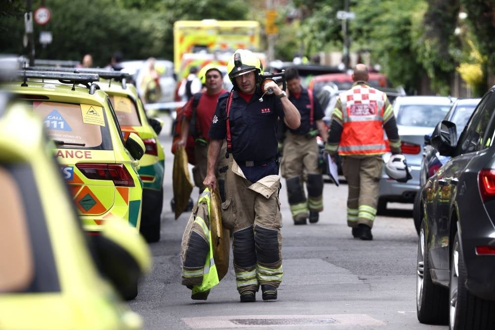 Rescue workers and firefighters walk near the private Study Prep girls' school following a car collision in Wimbledon, southwest London, on July 6, 2023. - (Photo by HENRY NICHOLLS / AFP)