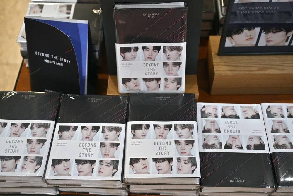 Copies of the BTS memoir titled "Beyond the Story: 10-Year Record of BTS" are seen on display at a bookstore in Seoul on July 9, 2023. K-pop megastars BTS released a hot-anticipated memoir in South Korea on July 9, to mark their 10th anniversary. (Photo by Jung Yeon-je / AFP)