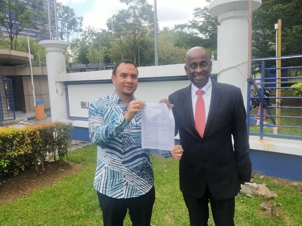 Ahmad Farhan (left) showing the police report with Sankara on Chegu Bard, Wan Saiful as well as Raggie Jessy Rithaudeen at the Putrajaya IPD on Thursday.