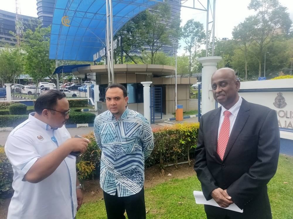 Ahmad Farhan (centre) and Sankara (right) speaking at the Putrajaya IPD grounds after lodging the report on Thursday.