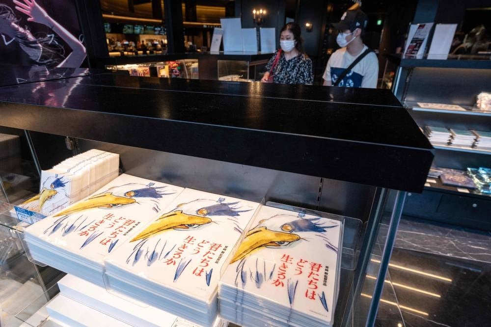 Merchandise for Oscar-winning animator Hayao Miyazaki's latest film, titled in English "How Do You Live?" is displayed for sale at a cinema on the first day of the film's premiere in Tokyo on July 14, 2023. - Photo by Richard A. Brooks / AFP