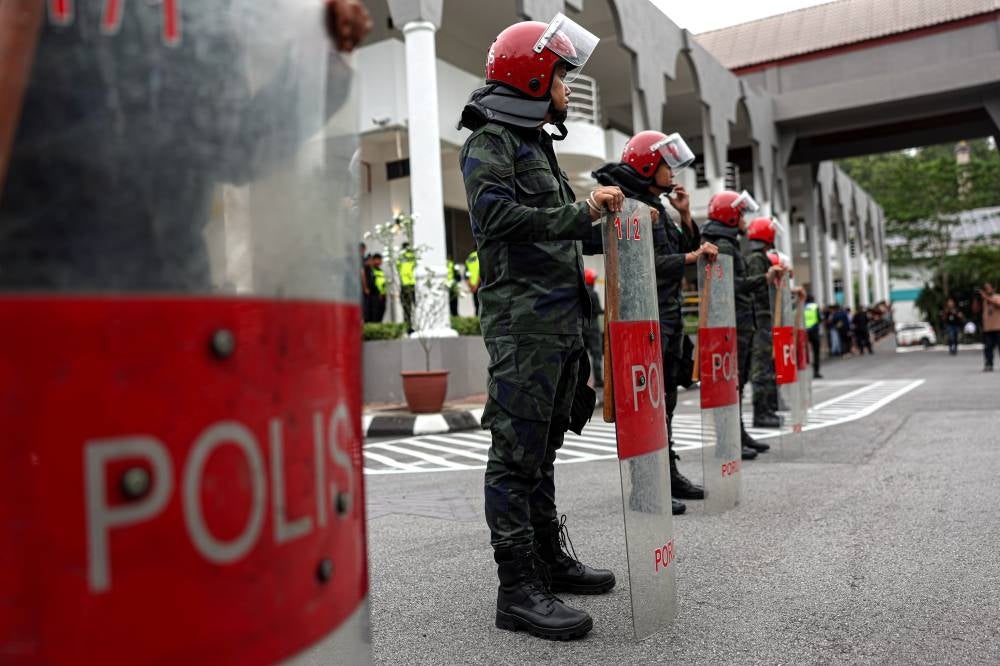 Public Order Riot Units (PORU) personnel monitoring the situation outside the Selayang Court as Caretaker Kedah Menteri Besar Datuk Seri Muhammad Sanusi Md Nor is facing charges over his remarks at a political talk. - Photo by Bernama 