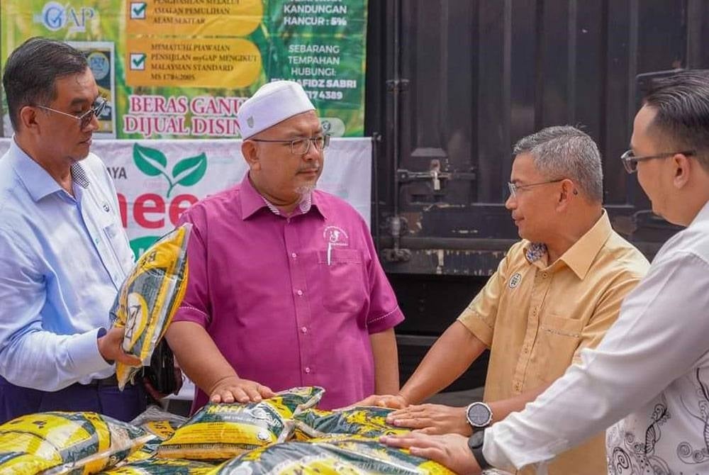 Wan Sukairi (second from left) met the sole distributor of Ganu rice in Kampung Losong Datuk Amar here. Photo: Wan Sukari's Facebook