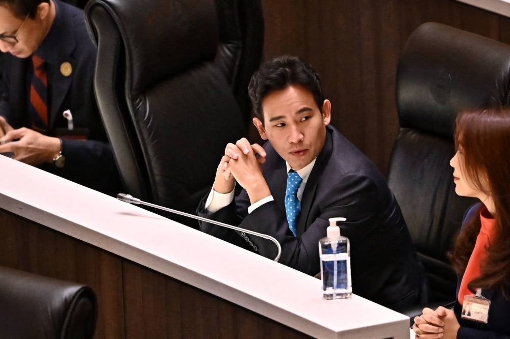 MFP leader and prime minister candidate Pita Limjaroenrat sits inside the Thai Parliament with fellow party members as deliberations proceed before the second round of the parliamentary vote to decide the country's next prime minister. (Photo by Lillian Suwanrumpha/AFP