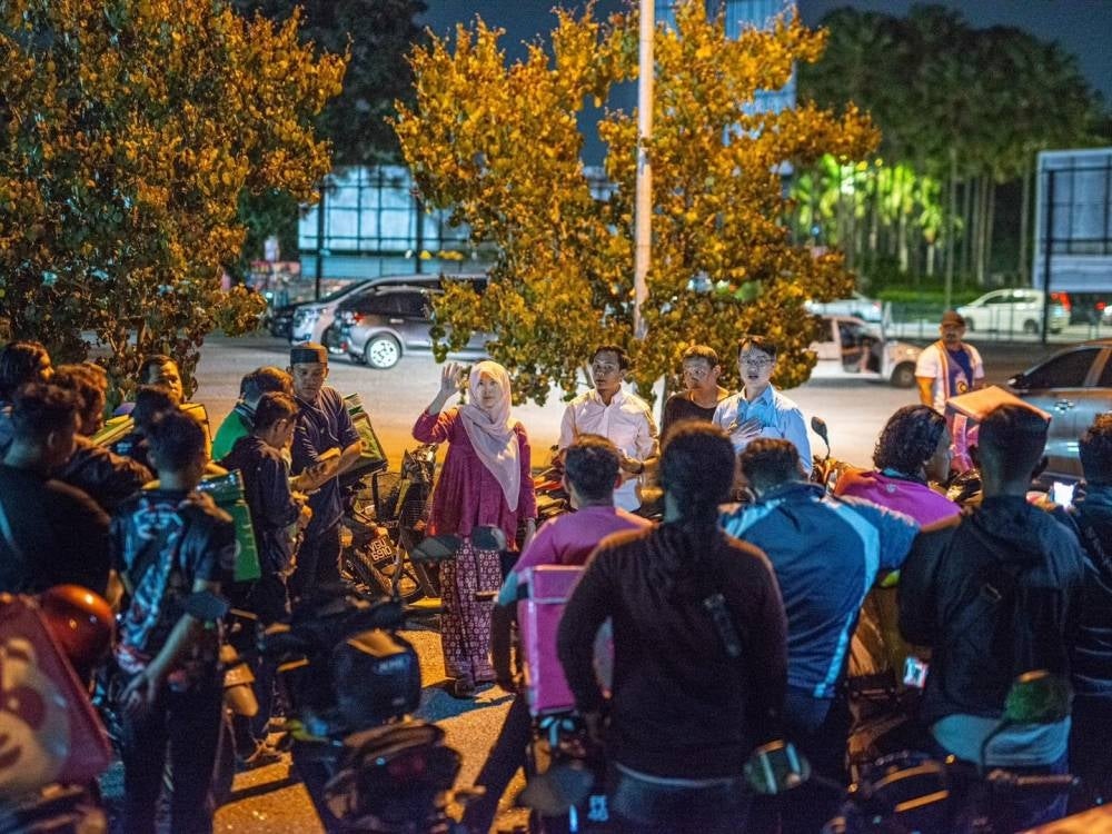PKR vice-president Nurul Izzah Anwar during a discussion with delivery riders.