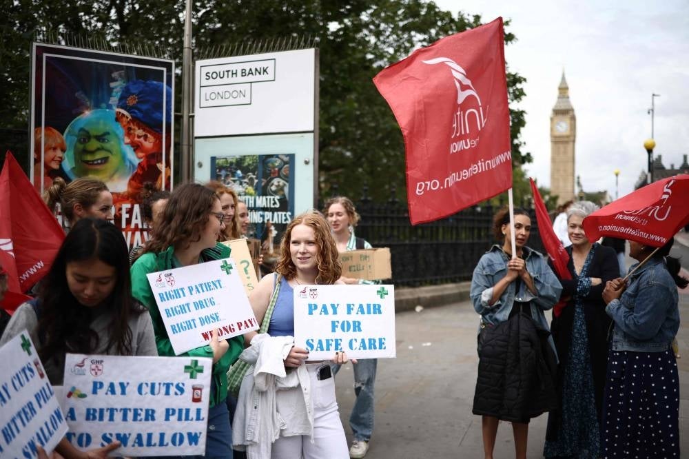 Junior doctors hold placards at a picket line outside St Thomas' Hospital in London on July 13, 2023 in the biggest walk out in the history of the UK's state-funded National Health Service. - Photo by Henry Nicholls / AFP