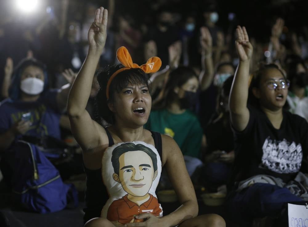 A supporter of Move Forward Party's leader and prime ministerial candidate Pita Limjaroenrat holds his iconic doll, as they flashes three-finger salute during the protest against Thai senators and a court, inside the Kasetsart University in Bangkok, Thailand, 21 July 2023. (Photo by EPA/NARONG SANGNAK)