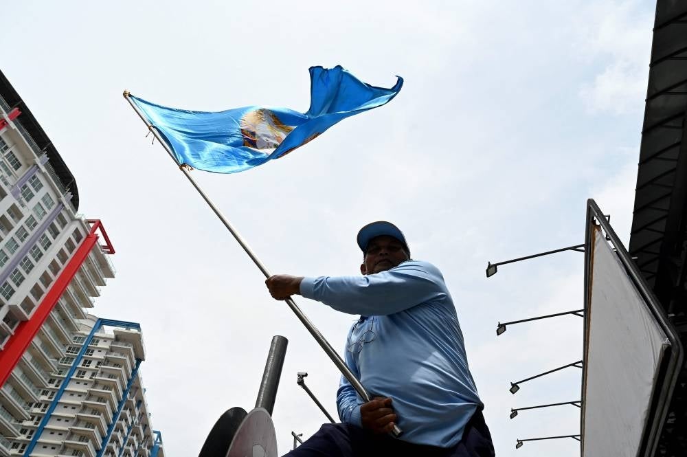 A supporter of Cambodian People痴 Party (CPP) waves a CPP flag during a campaign rally in Phnom Penh on July 21, 2023. (Photo by TANG CHHIN Sothy / AFP)