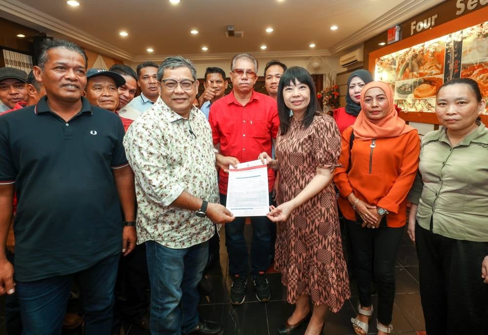 DAP Penang Secretary, Lim Hui Ying (third from the right), receiving the DAP membership form from former Deputy Chairman of Bersatu Kelantan, Zulkifli Zakaria (second from the left), here last night. -Bernama pix
