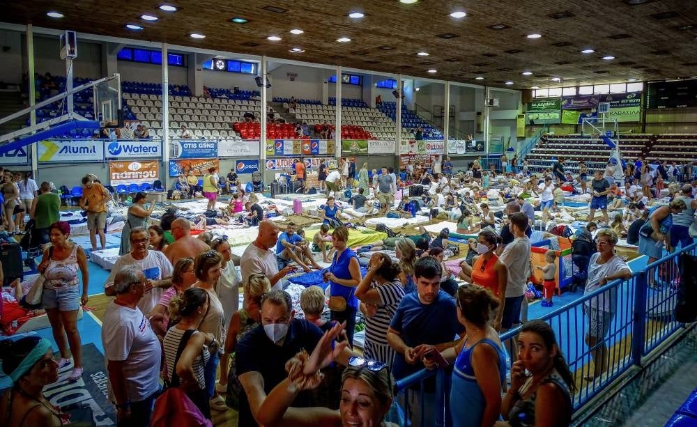 Tourists gesture in a basketball hall where they spent their night due to the wildfire in Rhodes, on the Greek island of Rhodes on July 23, 2023. - Photo by AFP