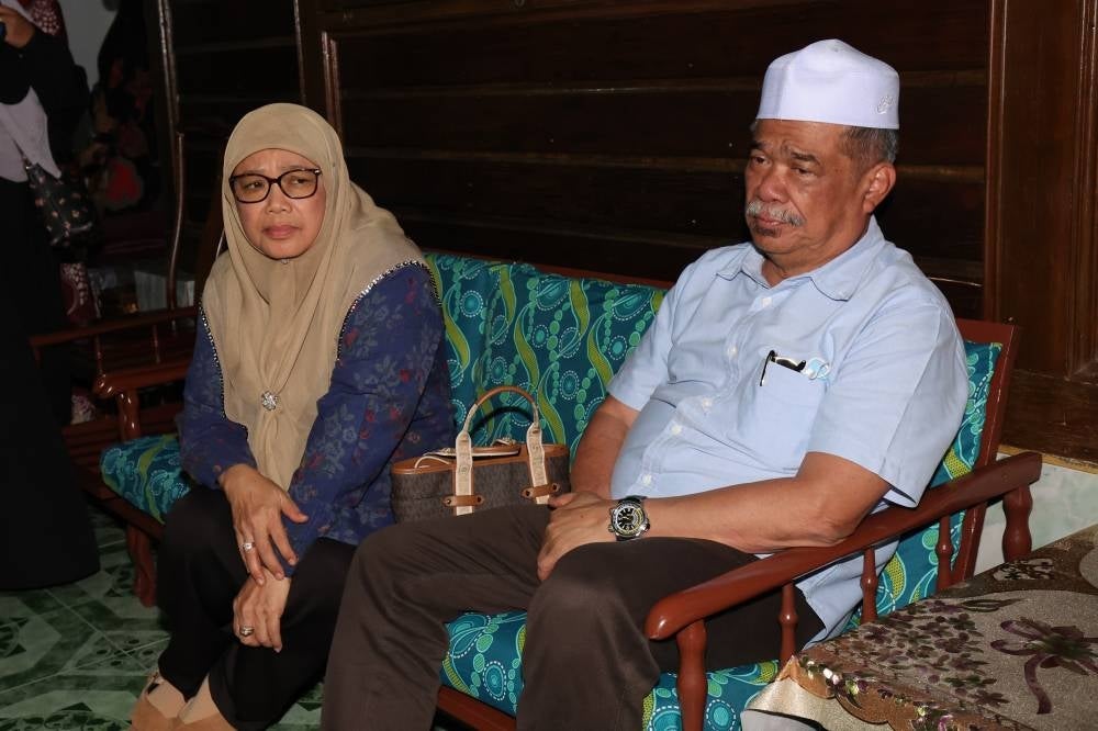 Datuk Seri Mohamad Sabu (right), pays his respects to the late Domestic Trade and Cost of Living Minister Datuk Seri Salahuddin Ayub, whose remains arrived at his mother's residence at 3:35am on Monday in Kampung Serkat Tanjung Piai today. - Photo by Bernama