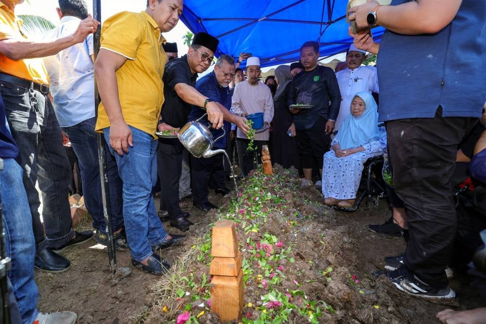 Higher Education Minister and Kota Tinggi MP, Datuk Seri Mohamed Khaled Nordin (second from the left), pours rose water on the grave of the late Datuk Seri Salahuddin Ayub at Jalan Sulong Cemetery, Serkat, Tanjung Piai today. - Photo by Bernama.