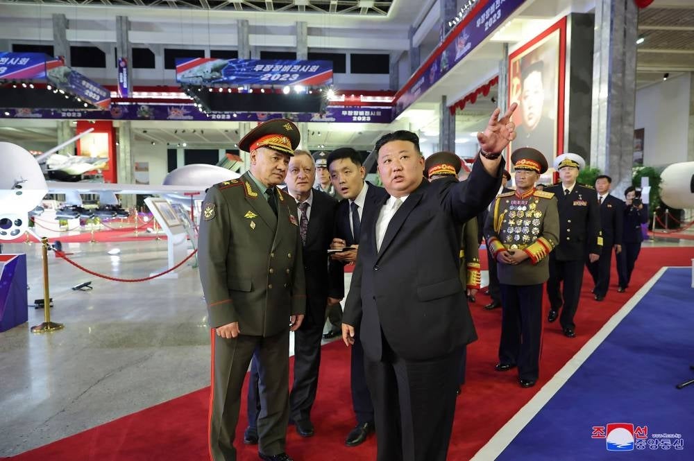 This picture taken on July 26, 2023 and released by North Korea's official Korean Central News Agency (KCNA) on July 27 shows North Korean leader Kim Jong Un (front R) visiting the weaponry exhibition house with Russian Defence Minister Sergei Shoigu (L) and members of the military delegation in Pyongyang. - Photo by AFP