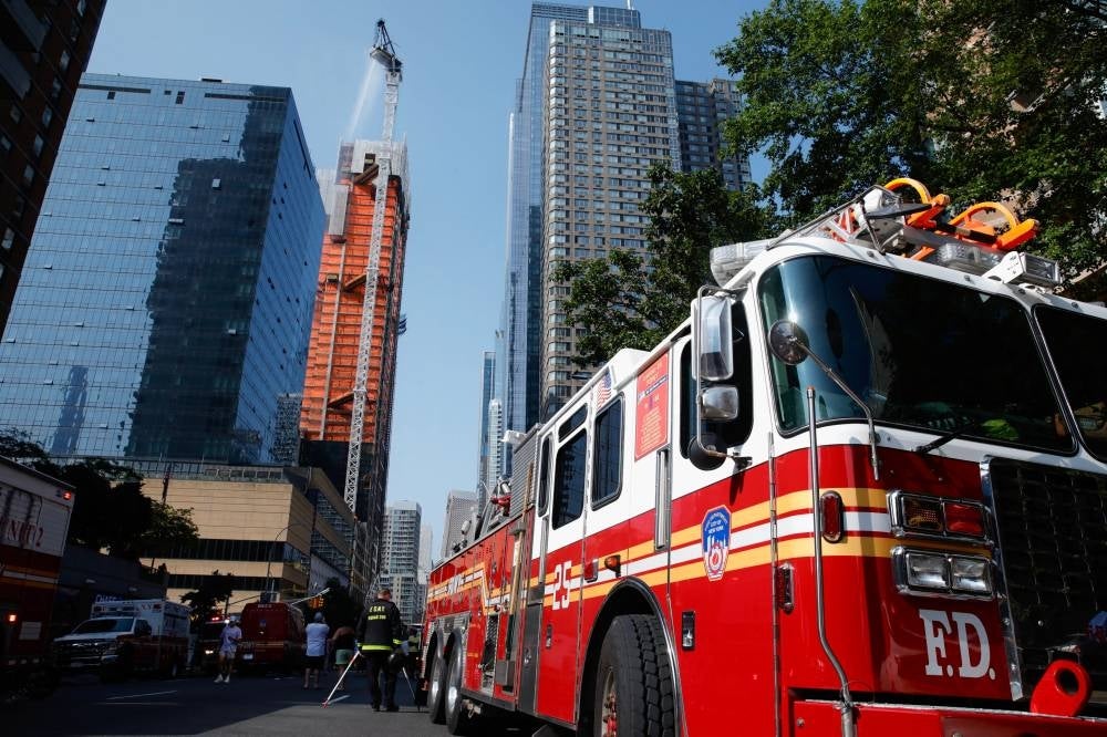 Firefighters battle a fire on a construction crane in New York, on July 26, 2023. Photo by Kena Betancur/AFP