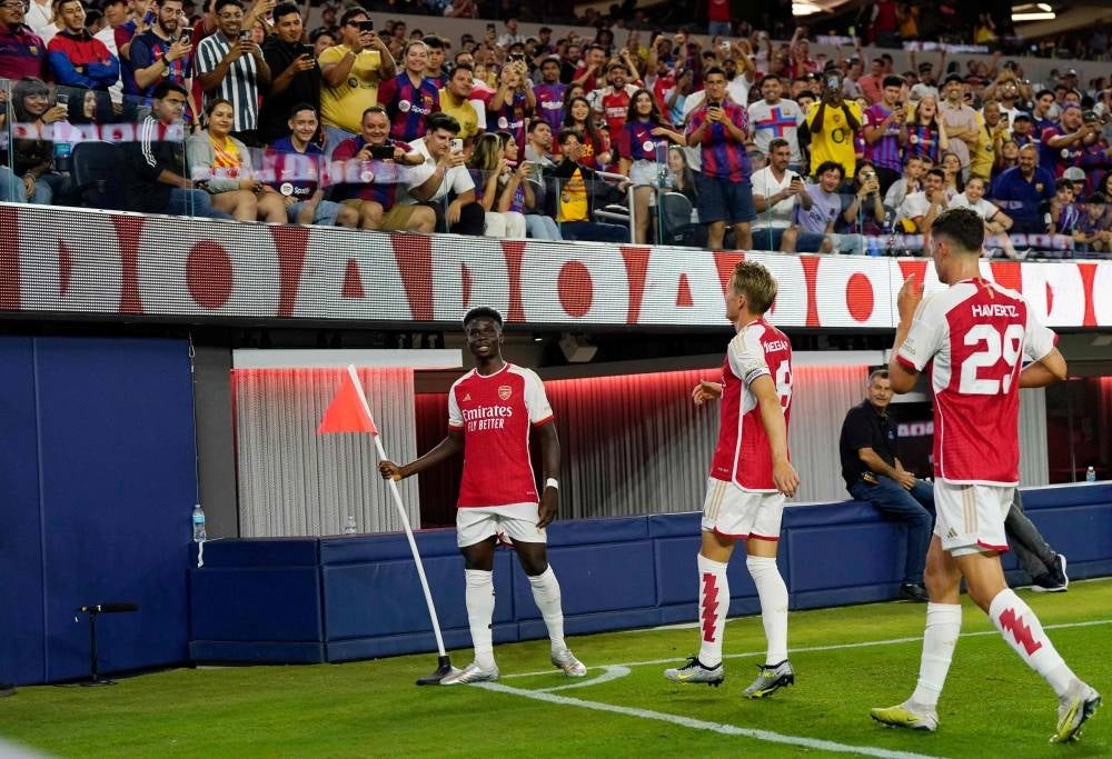 Bukayo Saka of Arsenal celebrates after he scored a goal against Barcelona with teammates Martin Odegaard and Kai Havertz during the first half of a pre-season friendly match between Arsenal and Barcelona at SoFi Stadium on July 26, 2023 in Inglewood, California. - Photo by AFP
