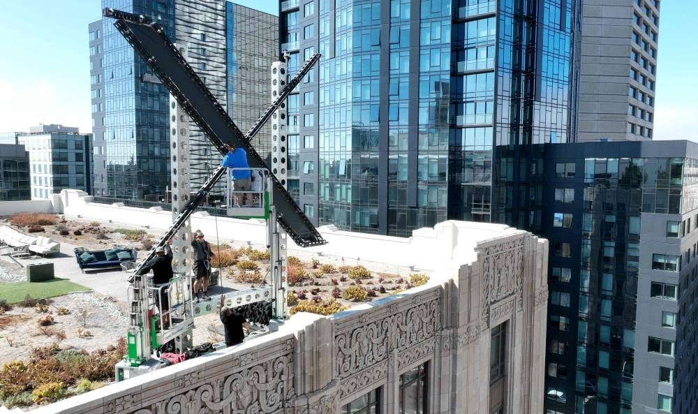 Workers start to dismantle a large X logo on the roof of X headquarters on July 31, 2023 in San Francisco, California. Photo by Justin Sullivan/AFP 