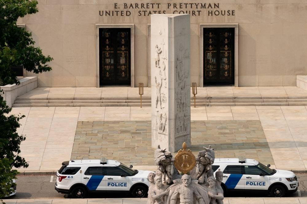 Police vehicles sit outside the Barrett Prettyman Courthouse, in Washington, DC, on Aug 1, 2023. - (Photo by Stefani Reynolds / AFP)