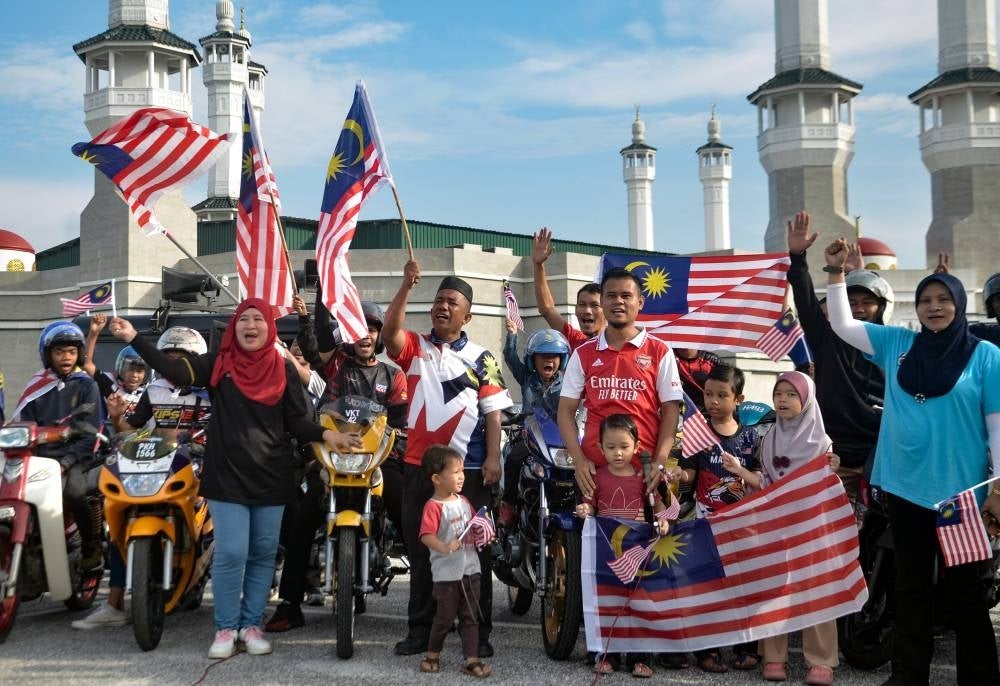A portion of the motorcycle convoy from nine Madani communities waving the Jalur Gemilang to show off their patriotic spirits. - BERNAMA PIX