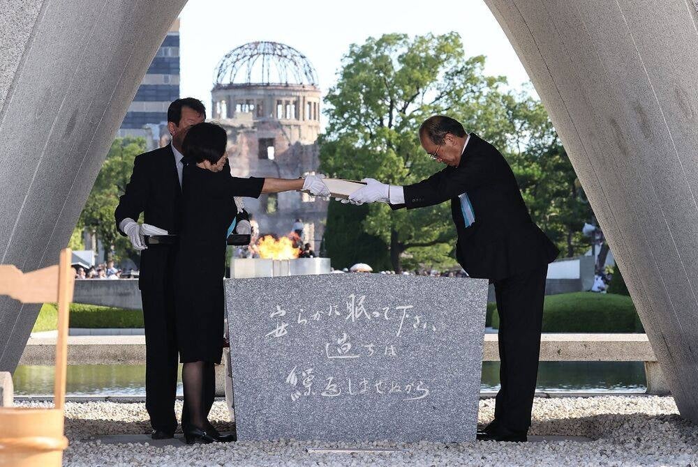 Hiroshima Mayor Kazumi Matsui (R) and representatives of bereaved families enshrine a list of the atomic bomb victims at the cenotaph during a ceremony to mark the 78th anniversary of the world's first atomic bomb attack, at the Peace Memorial Park in Hiroshima on August 6, 2023. (Photo by JIJI Press / AFP) / Japan OUT