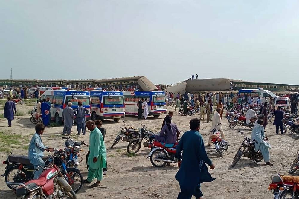 Local residents and ambulances are seen beside carriages following the derailment of a passenger train in Nawabshah, in the Pakistan's southern Sindh province on Aug 6, 2023. - Photo by AFP