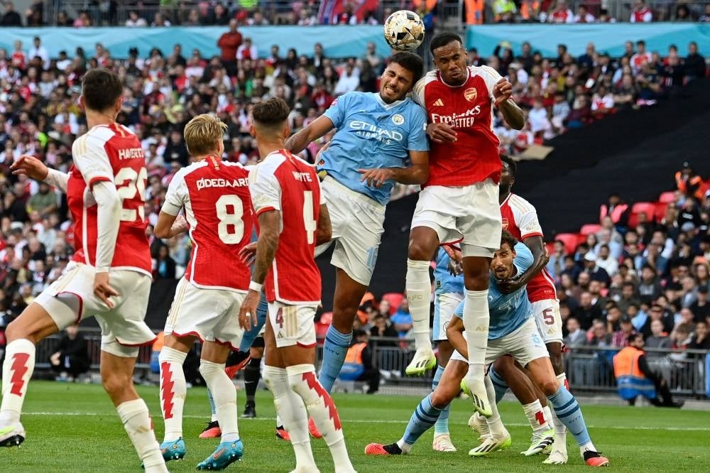 Arsenal's Brazilian defender Gabriel Magalhaes (R) vies with Manchester City's Spanish midfielder Rodri (C) during the English FA Community Shield football match between Arsenal and Manchester City at Wembley Stadium, in London, August 6, 2023. (Photo by JUSTIN TALLIS / AFP) 