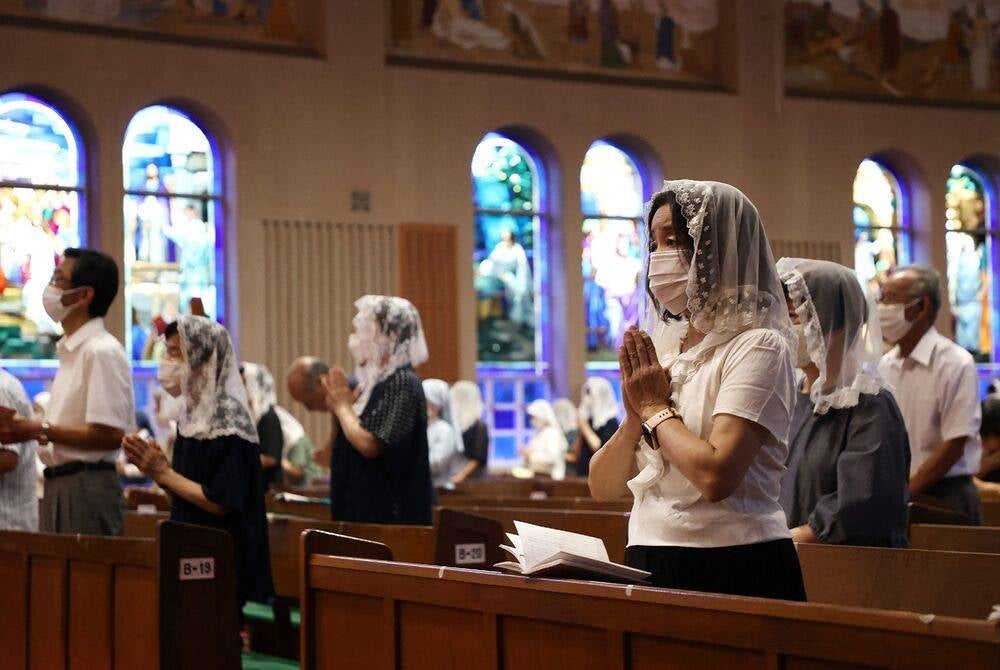 People offer prayers for the victims at a mass at Urakami Cathedral in Nagasaki, Nagasaki prefecture on Aug 9, 2023, as the city marks the 78th anniversary of the atomic bombing during World War II. (Photo by JIJI Press / AFP) / Japan OUT