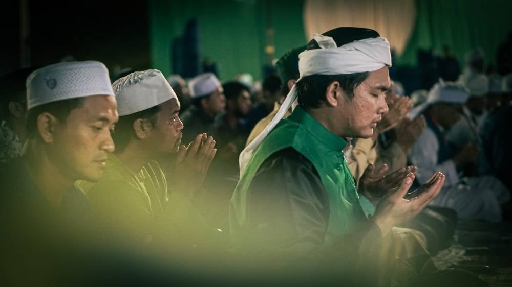 Like a steady heartbeat of devotion, the second last verse of the Ya-Sin was intoned with much reflection and unwavering faith; for forty-one repetitions by Pas supporters there at the Perikatan Nasional's Aug 8 mega rally. - Photo by ZAIDI AZMI