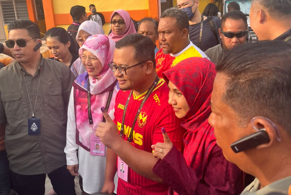 Amiruddin and Masdiana posing with their inked fingers after casting their votes. (Photo by Adlin)