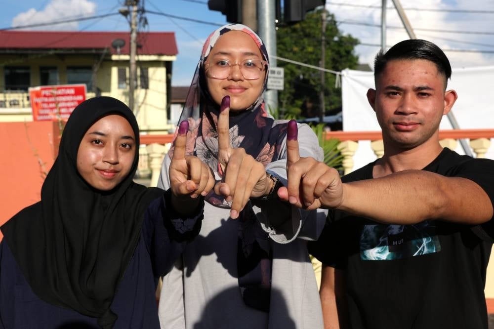 Three siblings Nurul Alani Fatini Norazlie, Aisha Norazlie dan Firas Faiq Norazlie show their inked finger after voting at Permatang Pasir, a constituency under the Permatang Pauh parliament, at Sekolah Kebangsaan Seri Penanti on Aug 12. (Photo by BERNAMA)